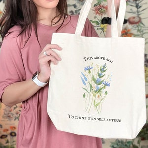 Pode incluir: Uma bolsa tote de lona branca com um design floral e o texto "This above all: To thine own self be true".