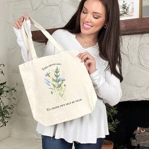 Pode incluir: Uma bolsa tote de lona branca com um design floral e o texto "This above all: To thine own self be true".