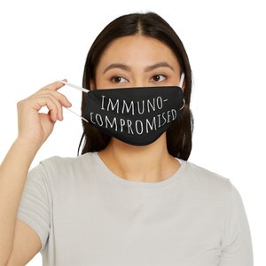 Pode incluir: Uma máscara facial preta com texto branco que diz "Imunocomprometido".
