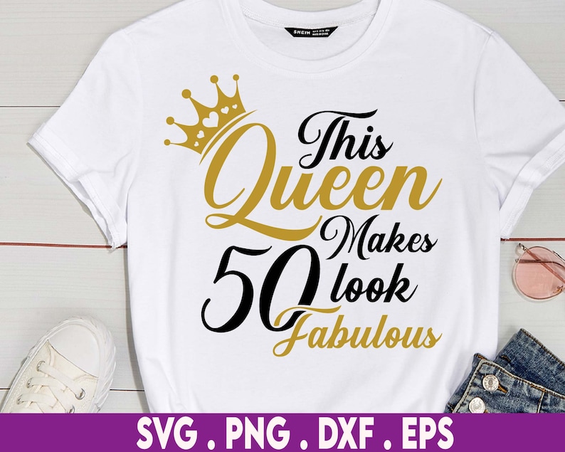 May include: White t-shirt with a gold crown and black text that reads "This Queen Makes 50 Look Fabulous".