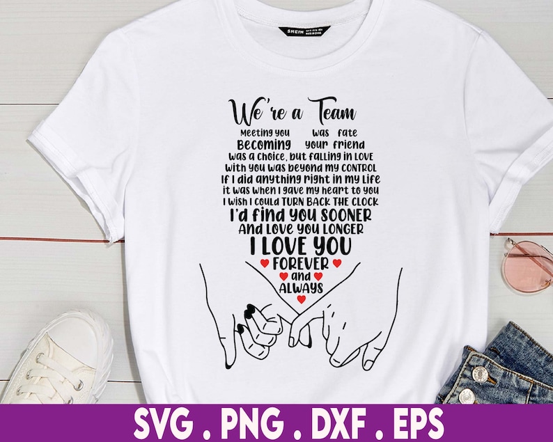 May include: White t-shirt with a black graphic design that says "We're a Team" and includes a quote about love and a couple holding hands. The graphic also includes red hearts.