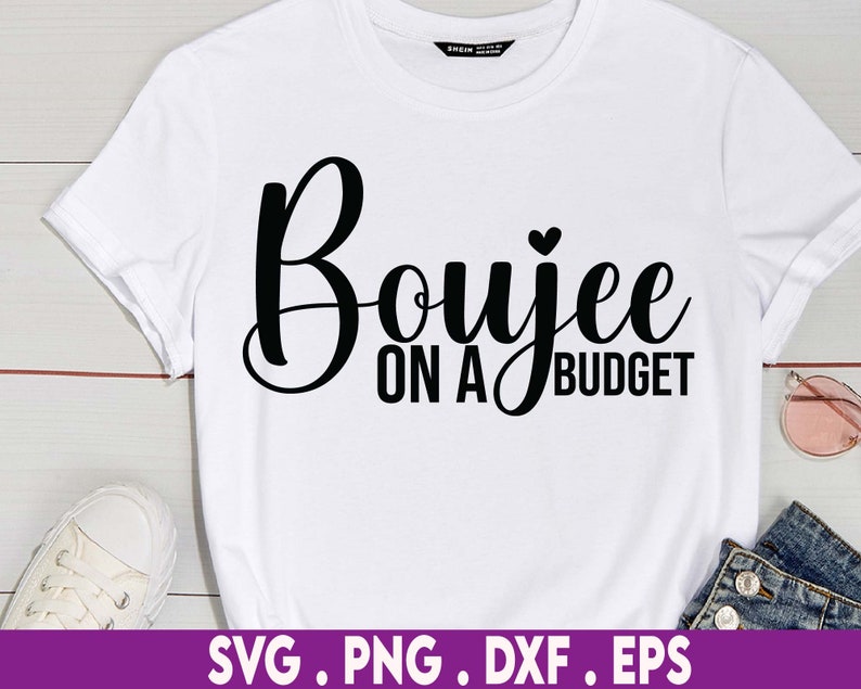 May include: White t-shirt with black text that reads "Boujee on a Budget" with a small heart above the word "Budget".