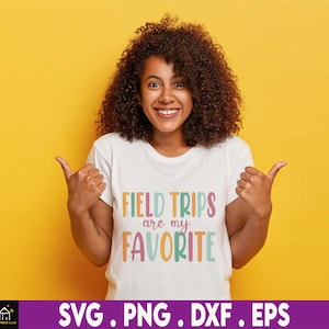 May include: A woman wearing a white t-shirt with the text "Field Trips are my Favorite" in colorful letters. The text is in a playful font and the colors are bright and cheerful.