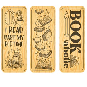 May include: Three wooden bookmarks with a light wood grain pattern. The left bookmark has the text "I READ PAST MY BEDTIME" with illustrations of books, a fox, and a cup of coffee. The middle bookmark features floating books. The right bookmark says "BOOKaholic" with a pencil illustration.