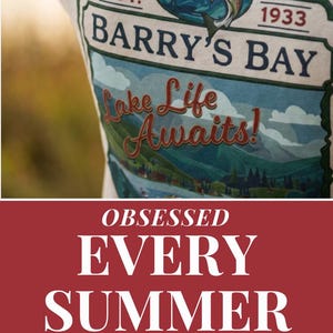 May include: A collection of apparel featuring a red sweatshirt with the white text LIFE HAPPENS, BARRY'S BAY HELPS, a cream t-shirt with a graphic of a fish and the text BARRY'S BAY EST. 1933 Lake Life Awaits!, and a green sweatshirt with white text.