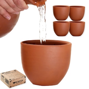 Puede incluir: Conjunto de cuatro tazas de arcilla de terracota con una jarra de terracota vertiendo agua en una de las tazas. Las tazas son marrones y tienen una forma redondeada. La jarra es marrón y tiene un asa. Las tazas están dispuestas en fila, con la jarra en el centro. El texto "4 PIECES" es visible en la caja.