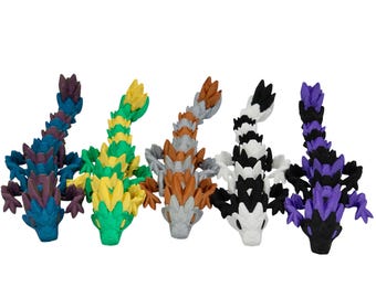 May include: Five colorful, segmented, bendable toys shaped like dragons. The dragons are purple, green, brown, black and white.