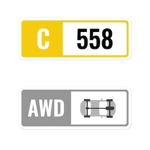 May include: Two rectangular stickers. The top sticker has a yellow section with the letter "C" and a white section with the number "558". The bottom sticker has "AWD" and a car axle graphic.