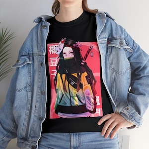 May include: Black t-shirt with a colorful illustration of a female anime character wearing a mask and a yellow jacket. The character is standing in front of a red and white background with Japanese text.