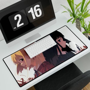May include: A white desk mat with a black border features an anime illustration of two girls with long hair. One girl has long black hair and the other has long blonde hair. The girls are looking at each other. The background is a light pink color with a floral pattern.