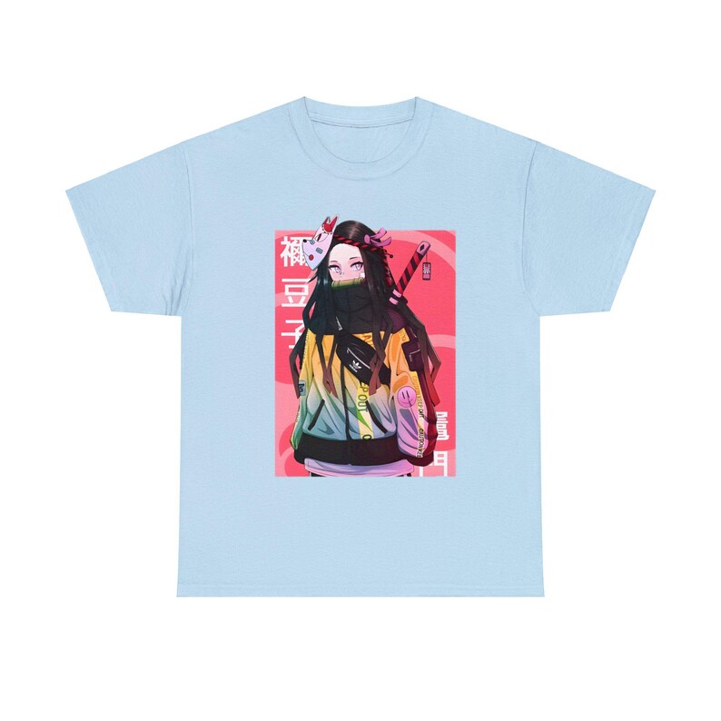 May include: Light blue t-shirt with a graphic of a female anime character wearing a yellow and green jacket, a black mask, and holding a sword. The character is standing in front of a pink and red background with Japanese text that reads "Demon Slayer".