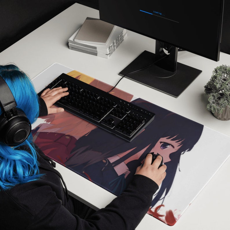 May include: A white and black anime-style mousepad with two female characters. The mousepad features a black keyboard and a person's hand using a computer mouse.