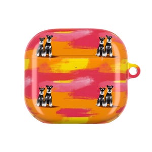 May include: A square-shaped protective case for wireless earbuds featuring a vibrant background of horizontal brushstrokes in shades of orange, yellow, and pink. The surface is decorated with a repeating pattern of small black and white Schnauzer dogs.