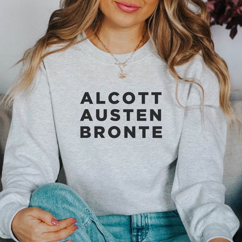May include: A gray sweatshirt with the text "ALCOTT AUSTEN BRONTE" printed in black.
