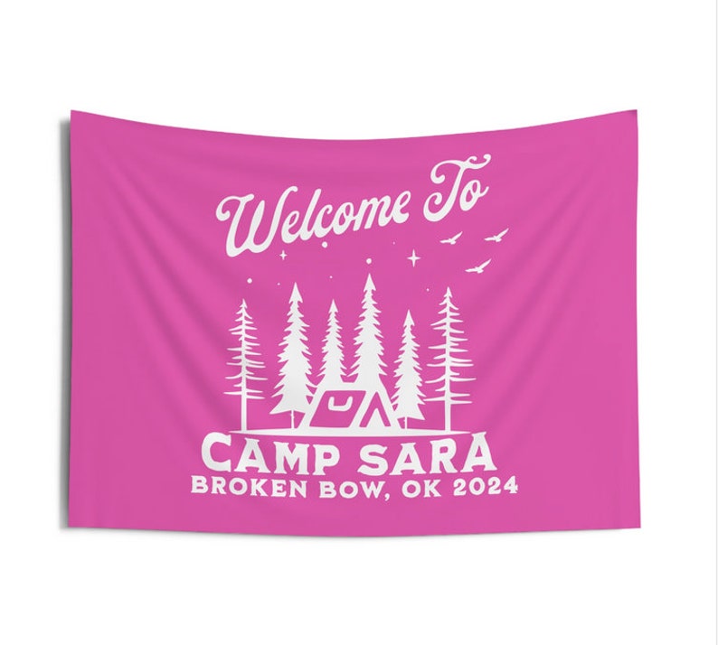 May include: Pink welcome banner with white text that reads "Welcome to Camp Sara Broken Bow, OK 2024". The banner features a stylized illustration of a tent and trees.