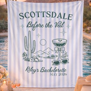 May include: A light blue and white striped backdrop with the text "SCOTTSDALE Before the Veil" and "Riley's Bachelorette MAY 2026". The backdrop features a desert-themed illustration with a cactus, mountains, and a cocktail.