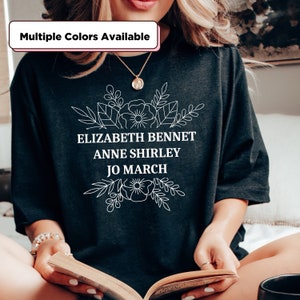 May include: Black t-shirt with white floral design and text that reads "Elizabeth Bennet Anne Shirley Jo March".