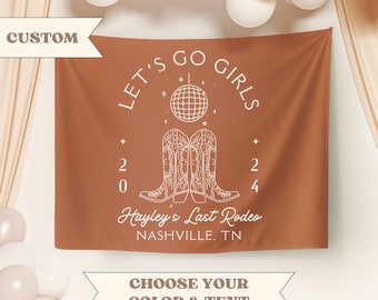 May include: A brown banner with white text that reads "Let's Go Girls" in a circle with a disco ball and two pairs of cowboy boots. The text "2024 Hayley's Last Rodeo Nashville, TN" is below the circle.