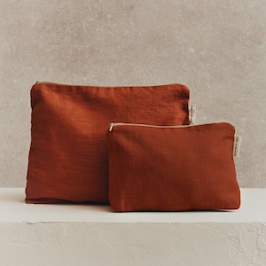 Neceser minimalista de lino color naranja óxido.