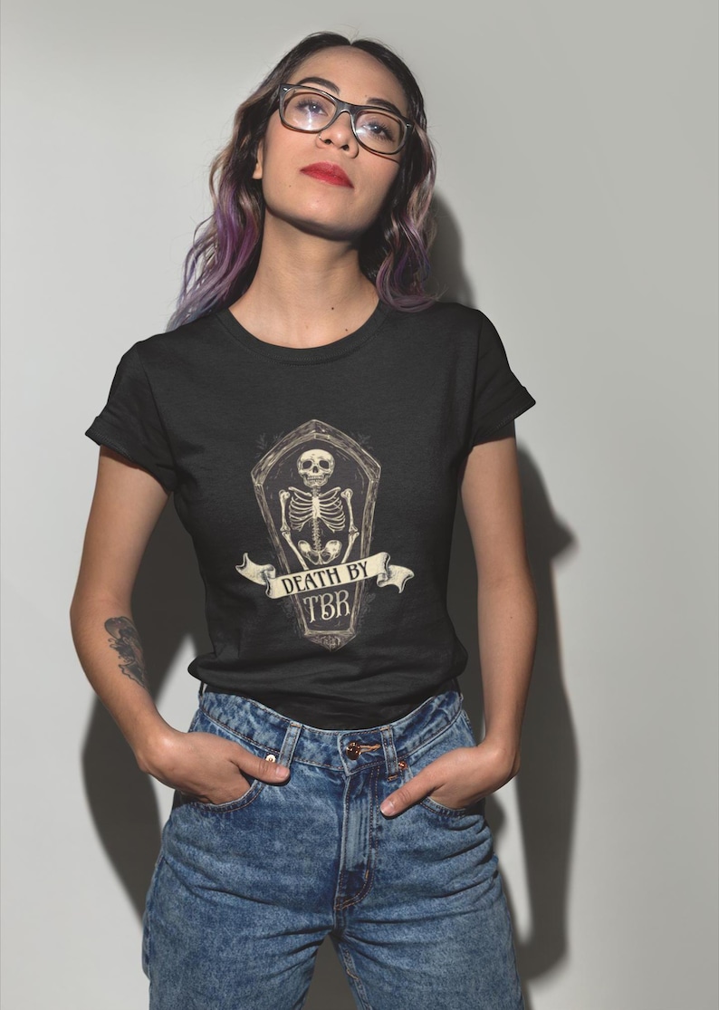 May include: A black t-shirt with a graphic of a skeleton in a coffin with the text "Death by TBR".