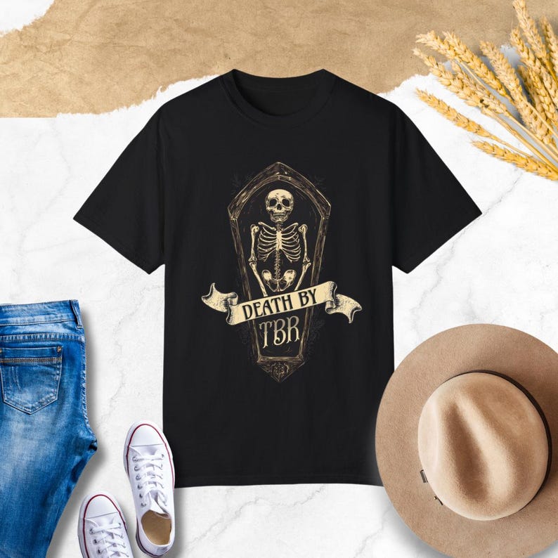 May include: Black t-shirt with a graphic of a skeleton in a coffin with the text "Death by TBR".