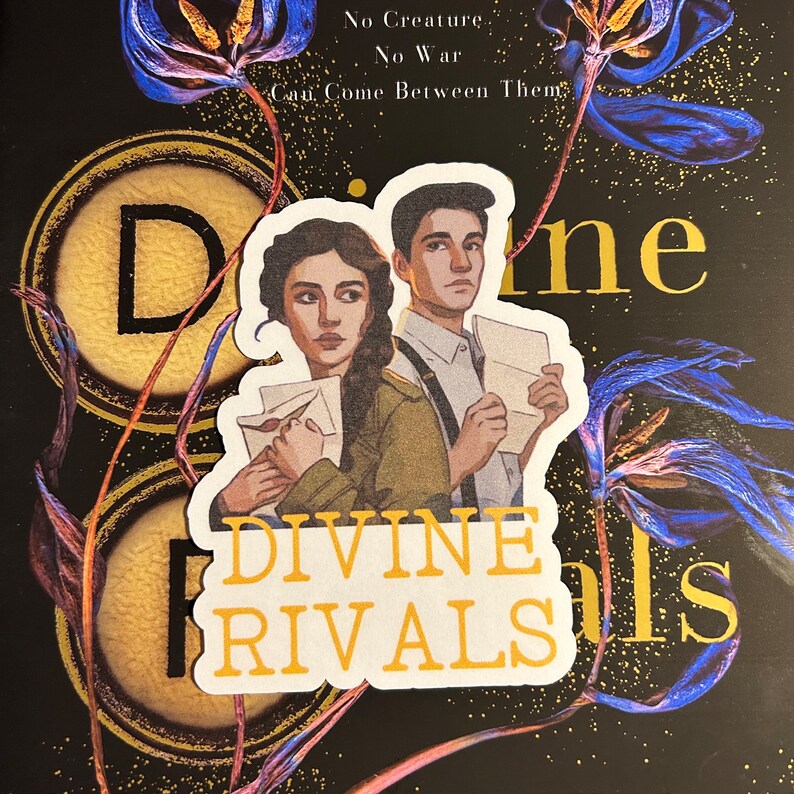 May include: A sticker featuring two characters from the book "Divine Rivals". The characters are a young woman with long brown hair and a young man with short brown hair. They are both holding letters. The sticker is white with the words "Divine Rivals" in yellow text.
