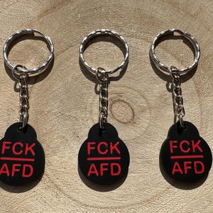 FCK AFD ショッピング カート チップ - 赤い文字付き |右翼ポピュリズムに対抗する政治的抗議キーホルダー、強力なショッピングカートリリーサー