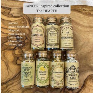 May include: Seven clear glass jars with cork stoppers, each containing dried herbs labeled Jasmine, Indian Hawthorn Berries, Mugwort, Angelica Root, Lemon Balm, Chamomile, and White Sage. Text reads CANCER inspired collection The HEARTH.