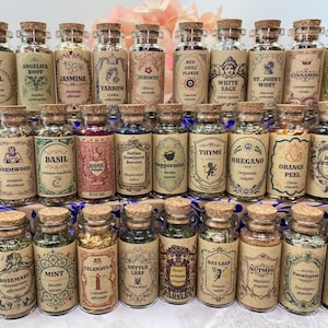 May include: A collection of small glass apothecary jars with cork stoppers, each containing dried herbs or spices. The jars feature vintage-style tan paper labels with botanical names, scientific names, and decorative illustrations.