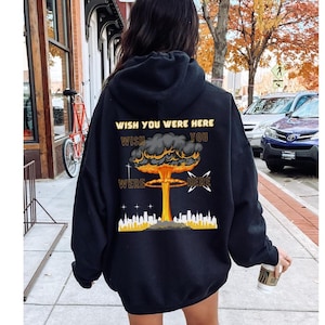 May include: Black hoodie with a graphic of a mushroom cloud and the text "Wish You Were Here" printed on the back.