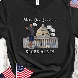 Könnte beinhalten: Schwarzes T-Shirt mit einem Grafikdruck eines Mannes, der vor dem US-Kapitol steht. Der Text "Make Our Senators SLOBS Again" ist auf dem Shirt aufgedruckt.