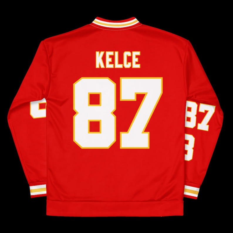 Puede incluir: Jersey rojo de manga larga con ribetes blancos y dorados. El jersey tiene el nombre "KELCE" y el n&uacute;mero "87" en la espalda.