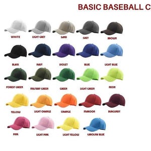 K&ouml;nnte beinhalten: Eine Sammlung von f&uuml;nfundzwanzig Baseballkappen, die in einem Raster angeordnet sind, wobei jede eine andere einfarbige Farbe aufweist, darunter Wei&szlig;, Grau, Braun, Schwarz, Marineblau, Violett, Blau, Gr&uuml;n, Gelb, Orange, Kastanienbraun, Rosa und Carolina-Blau mit Text.