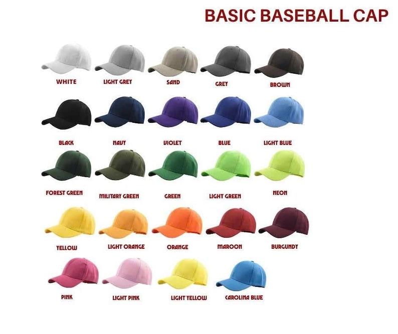 K&ouml;nnte beinhalten: Eine Sammlung von f&uuml;nfundzwanzig Baseballkappen, die in einem Raster angeordnet sind, wobei jede eine andere einfarbige Farbe aufweist, darunter Wei&szlig;, Grau, Braun, Schwarz, Marineblau, Violett, Blau, Gr&uuml;n, Gelb, Orange, Kastanienbraun, Rosa und Carolina-Blau mit Text.