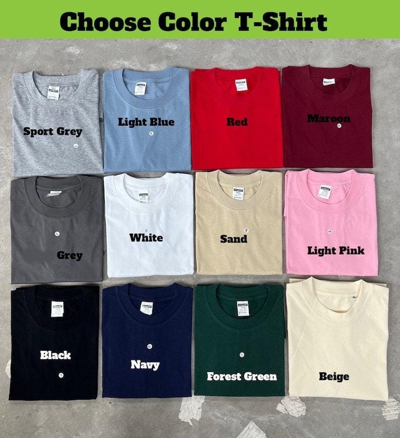May include: A selection of crew neck t-shirts in various colors, including sport grey, light blue, red, maroon, grey, white, sand, light pink, black, navy, forest green, and beige. The text "Choose Color T-Shirt" is at the top.
