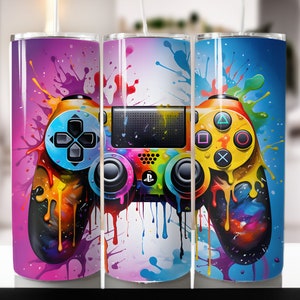 May include: A colorful, abstract design of a video game controller with paint splatters on a stainless steel tumbler.