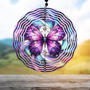 Peut inclure: Un mobile en métal violet et bleu avec un motif de papillon. Le papillon a un corps orné de bijoux et des ailes irisées.