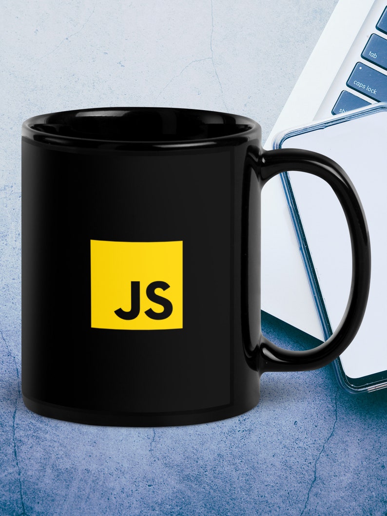 Op de afbeelding: Zwarte keramische koffiemok met een geel vierkant met de letters "JS" in zwart.