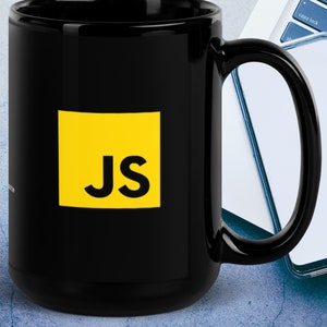 Op de afbeelding: Zwarte keramische mok met een geel vierkant met de letters "JS" in zwart.