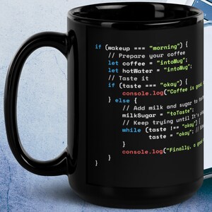 Op de afbeelding: Een zwarte koffiemok met een wit ontwerp met code die luidt "if (wakeup === "morning") { // Prepare your coffee let coffee = "intoMug"; let hotWater = "intoMug"; // Taste it if (taste === "okay") { console.log("Coffee is good"); } else { // Add milk and sugar to taste milkSugar = "toTaste"; // Keep trying until it's also okay while (taste !== "okay") { taste = "okay"; // Since it's also okay console.log("Finally, a good cup of coffee"); } } }"