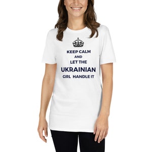 Könnte beinhalten: Weißes T-Shirt mit einem schwarzen Kronen-Motiv und dem Text "Keep Calm and Let the Ukrainian Girl Handle It" in Marineblau.