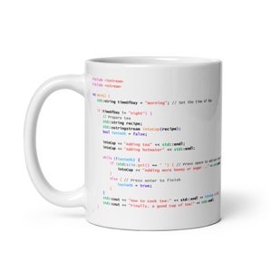 Könnte beinhalten: Eine weiße Keramiktasse mit einem bunten Code-Snippet darauf gedruckt. Der Code ist in C++ geschrieben und enthält Kommentare, die die Schritte zur Zubereitung einer Tasse Tee erklären. Der Code enthält den folgenden Text: "Tee hinzufügen", "Heißes Wasser hinzufügen", "Wie man Tee kocht" und "Schließlich eine gute Tasse Tee!"