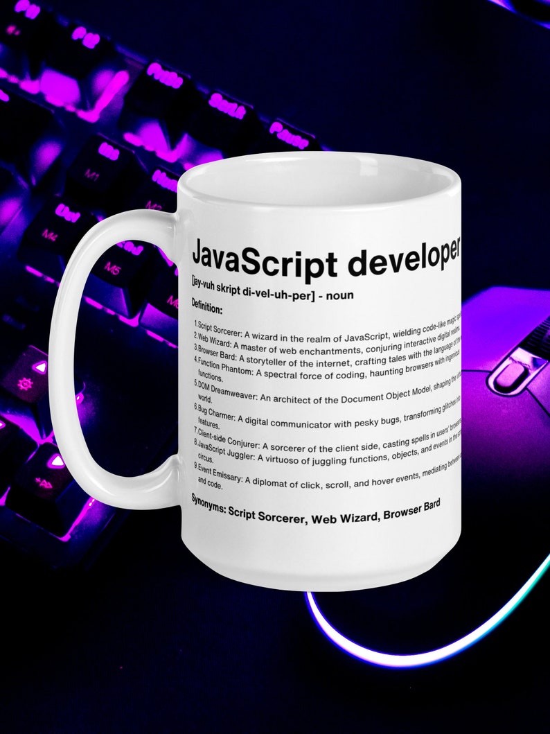 Pu&ograve; includere: Una tazza in ceramica bianca con un designo nero che definisce uno sviluppatore JavaScript come un "mago nel regno di JavaScript". La tazza ha un manico nero e si trova su una tastiera viola.