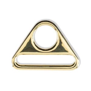 May include: Gold-toned metal triangle-shaped D-ring with a large oval opening and a smaller rectangular opening.