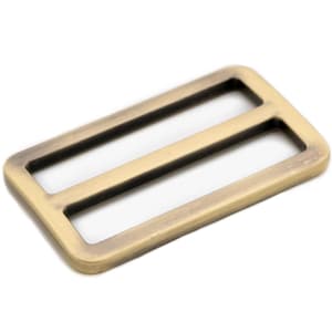 May include: A gold-toned metal buckle with two rectangular openings. The buckle has a brushed finish.