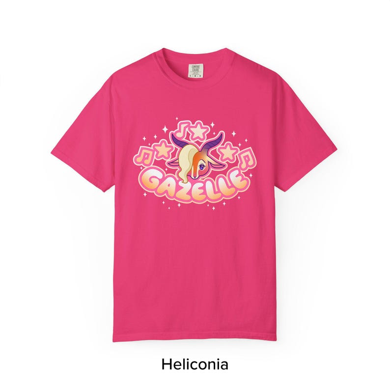 May include: A magenta t-shirt featuring a cartoon gazelle design with musical notes and stars. The gazelle has a cream-colored mane and purple horns. The word "Gazelle" is written in a bubble font. The text "Heliconia" is at the bottom.