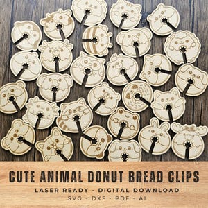 May include: A collection of laser-cut wooden donut-shaped bread clips, each featuring a different animal face design. The clips are light brown with black stems, and the text "CUTE ANIMAL DONUT BREAD CLIPS" is visible at the bottom.