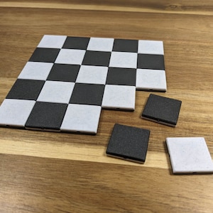Könnte beinhalten: Ein Schachbrett mit schwarzen und weißen Feldern, bei dem vier Teile fehlen. Die Teile sind schwarze und weiße Quadrate.