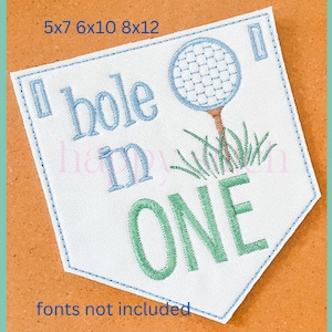 May include: A white fabric patch with blue and green embroidery. The patch features a golf ball, a golf club, and the text "Hole in One".