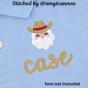 May include: Light blue polo shirt with an embroidered design. The design features a Santa Claus face wearing a cowboy hat, with the name "case" embroidered below. The text "Stitched by @amytcannon" and "font not included" are also visible.